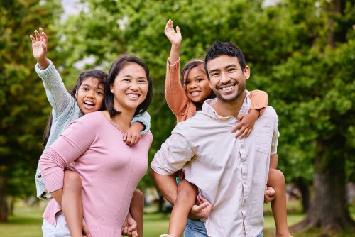Family of four smiling together outdoors