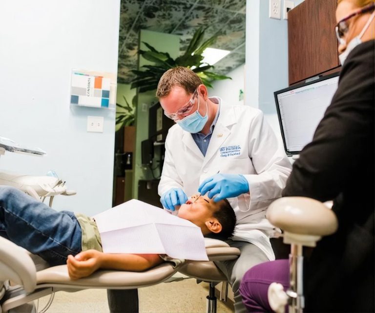 Smile Magic dentist examining a young patient in the treatment chair