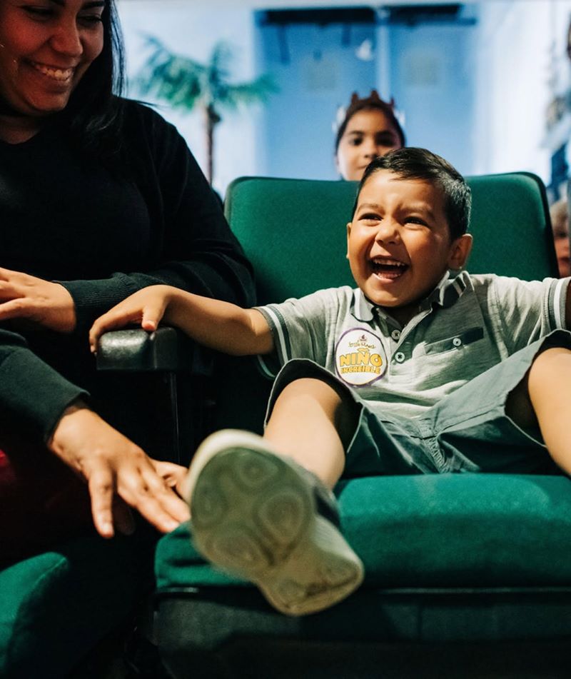 Child laughing in a dental chair while their family looks on