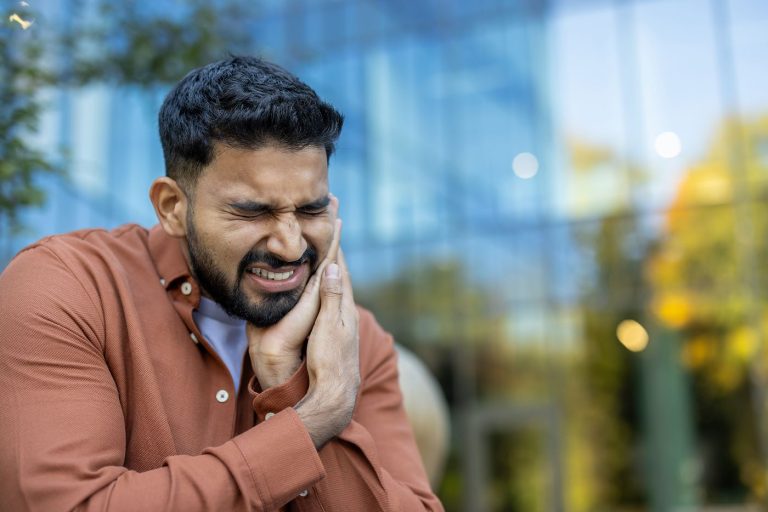 Man holding his jaw in pain from a toothache