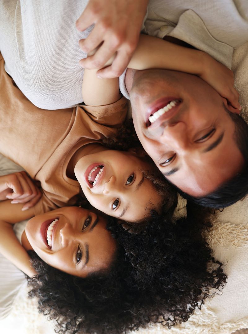 Parents and two children lying together and smiling