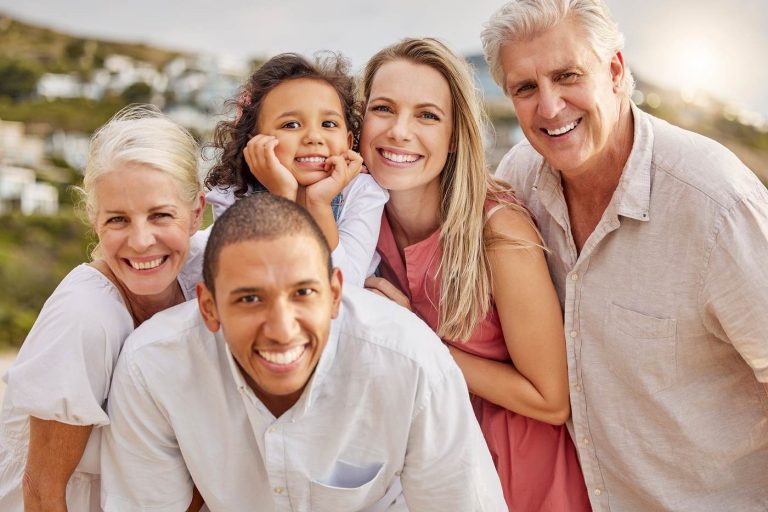 Three generations of a family smiling together outdoors