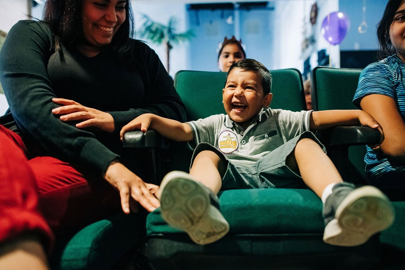 Child laughing in a dental chair while their family looks on
